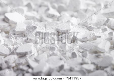 Calcium chloride (CaCl2) flakes. Common applications include brine for refrigeration plants, ice and dust control on roads, and desiccation. 