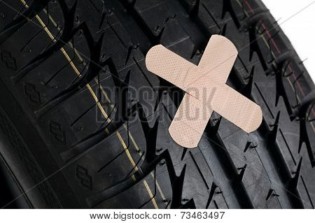 black new tire with patch on white