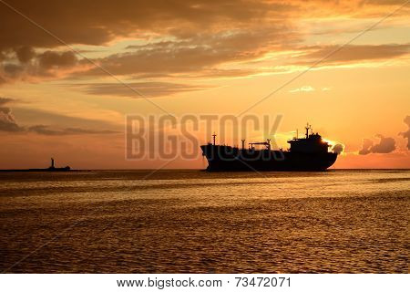 sunset at pier and a passing ship