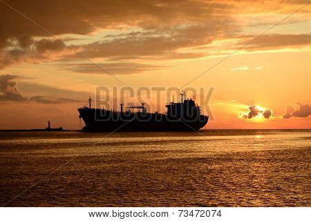 sunset at pier and a passing ship