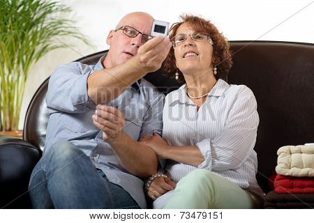 A Senior Couple Looks At A Photograph Slide