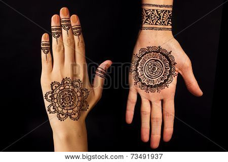 hand with mehendi on black background