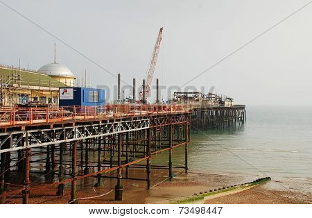 HASTINGS, ENGLAND - SEPTEMBER 20, 2014: A 39mtr crane mounted on a jack-up barge takes part in the reconstruction of the Victorian pier. Wrecked by fire in October 2010, the pier will re-open in 2015.