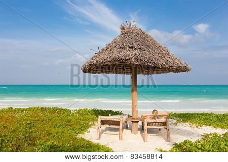 Woman sunbathing on tropical beach.