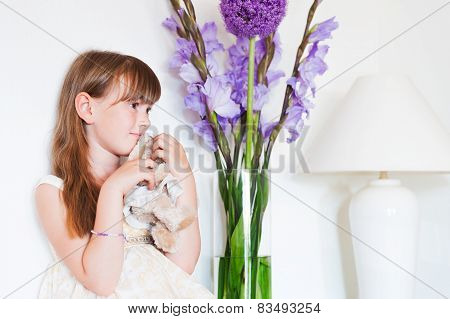 Interior portrait of a cute little girl with a toy