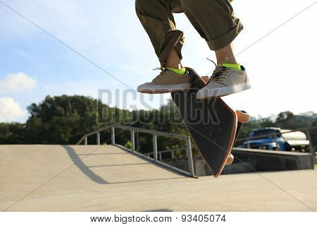 skateboarder legs doing heelflip at skatepark