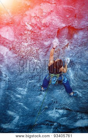 Rock climber climbing up a cliff