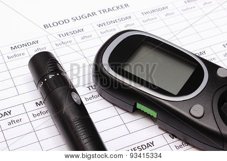 Glucometer And Lancet Device On Empty Medical Forms For Diabetes