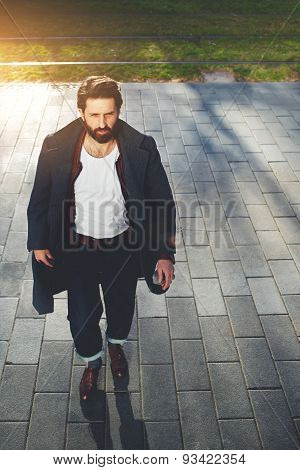 Portrait stylish hipster man walking on the street at sunny evening filter and flare sun