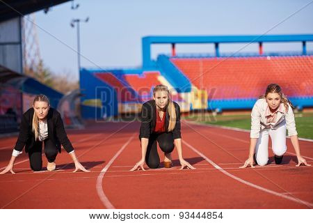 business woman in start position ready to run and sprint on athletics racing track