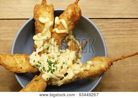 Chicken brochettes bowl with sauce.