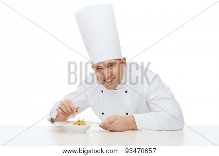 cooking, profession, haute cuisine, food and people concept - happy male chef cook decorating dish