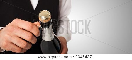 Portrait of a waiter holding a champagne bottle, celebration concept