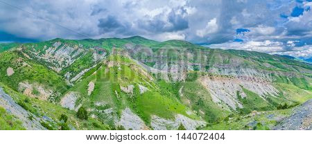 Panorama of Geghama Mountain Range covered with heavy grey clouds Gegharkunik Province Armenia.