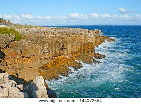 The winding rocky coast of Atlantic Ocean is the best place for the daily walk enjoying the nature's beauty in Cascais resort Portugal.
