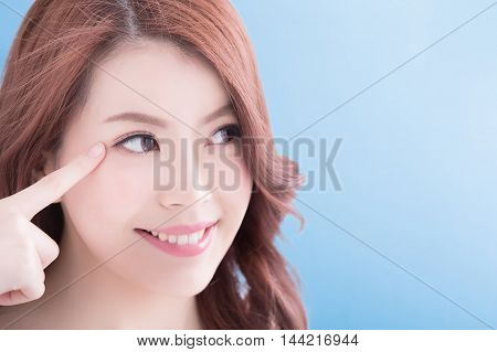 Woman face and eye care and she touch eye with hands asian beauty. Isolated over blue background asian beauty