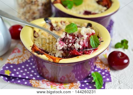 Cherry crumble with porridge on a concrete background