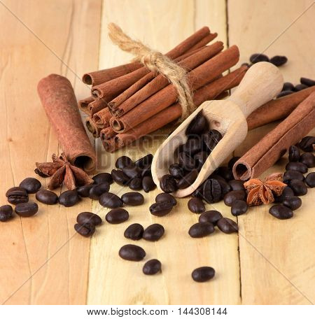Fragrant cinnamon sticks star anise and coffee beans on the wooden background. Christmas flavors. The festive mood Close-up./select focus/