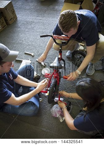 NEW YORK MAY 26 2016: USO volunteers and Navy personnel assemble bicycles for children of the crew in the hangar bay of the USS Bataan (LDH 5) at the Build-A-Bike event for Fleet Week 2016.