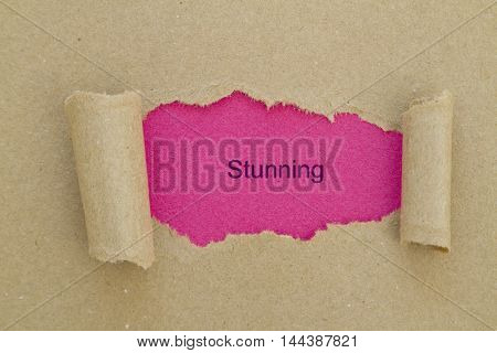 Stunning word written under torn paper .