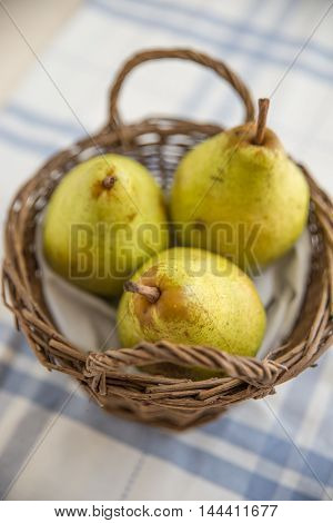 Pears with autumn leaves on wooden background