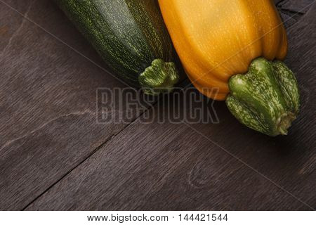 Two yellow green zucchini on wooden table..Closeup