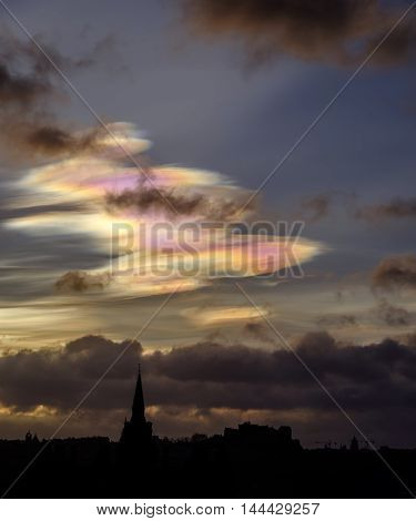 Edinburgh skyline silhouetted against early morning sky with beautiful rare nacreous clouds.