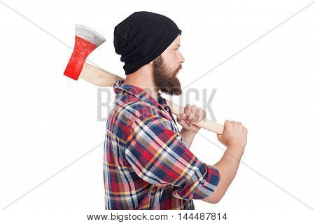 Confident young bearded man holding an axe and looking away while standing against white background