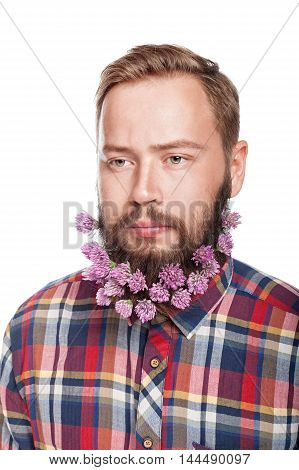 Portrait of handsome man with beard of clover flowers isolated on white