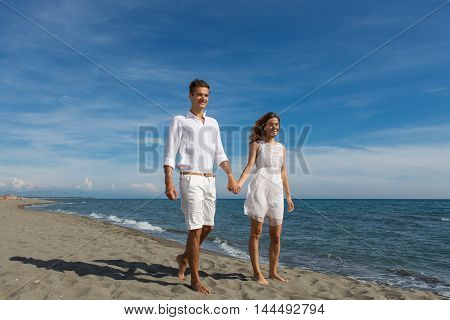 happy couple in love walking on the beach in summer white dress