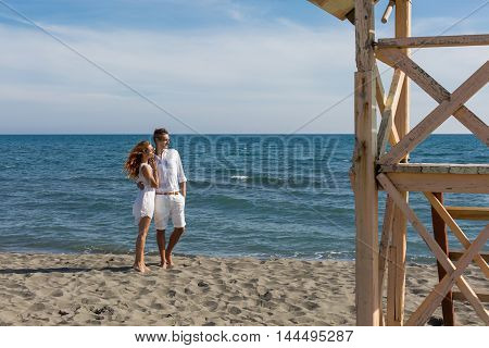 happy couple in love walking on the beach in summer white dress