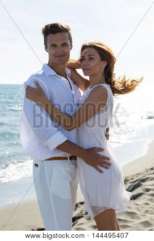 happy couple in love walking on the beach in summer white dress