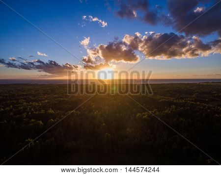 Aerial view of sunset at forest side with lake horizon