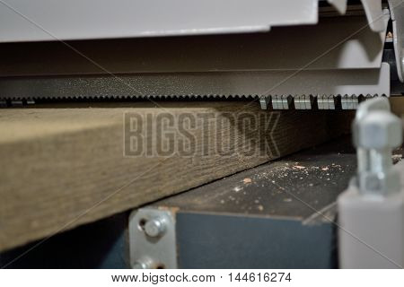 thick wooden board is treated with a planer