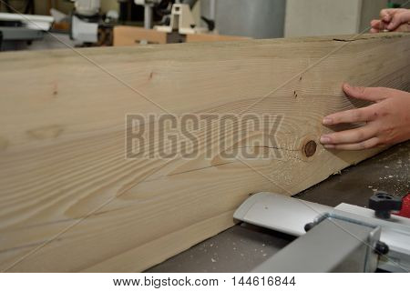 Wooden board is treated by a carpenter with a planer