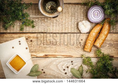 Cooking on a wooden table with ingredients and sausage