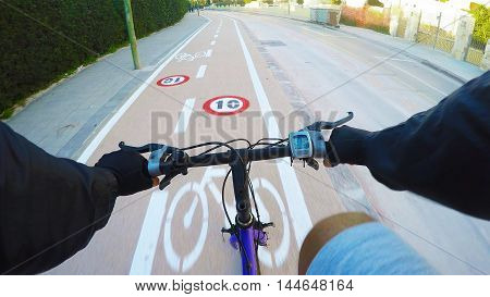 first person view of a man cycling on a bike lane