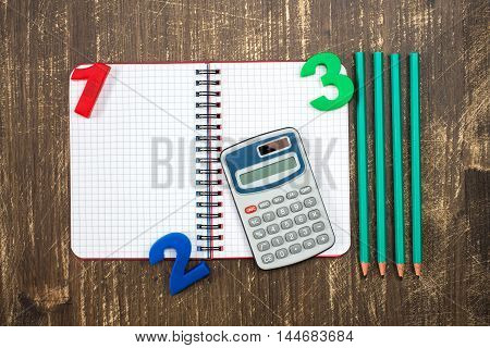 Digital calculatoropen notebookcolor numbers and pencil.Top view.