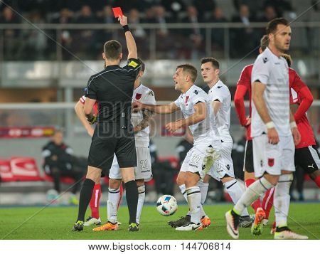 VIENNA, AUSTRIA - MARCH 26, 2016: Referee Ivan Kruzliak (Slovakia) shows the red card to Ergys Kace (Albania)  in a friendly football game.