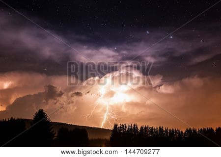 Beautiful view of dramatic dark stormy sky and lightning over small willage at night. Germany, Bavaria.