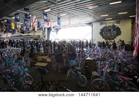 NEW YORK MAY 26 2016: USO volunteers and Navy personnel assemble bicycles for children of the crew in the hangar bay of the USS Bataan (LDH 5) at the Build-A-Bike event for Fleet Week 2016.