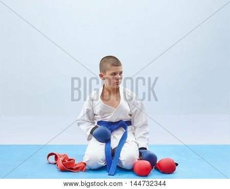 Little athlete and outfit karate on the light background
