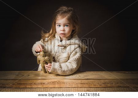 poor little girl playing with a straw bear