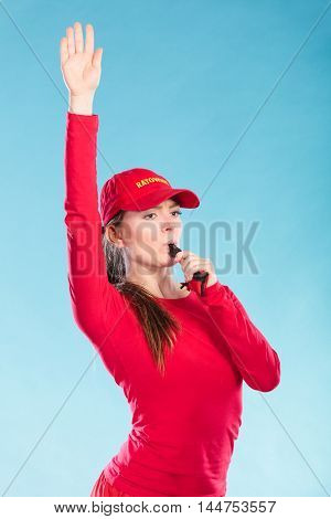 Lifeguard Woman In Cap On Duty Blowing Whistle.