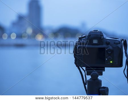 Closeup of a camera on a tripod outdoors. Background Landscape out of focus, select focus