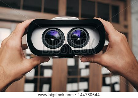 Virtual reality glasses with image inside. Hands holding vr goggles with picture of movie to watch. Modern technology, innovation, cyberspace, entertainment concept