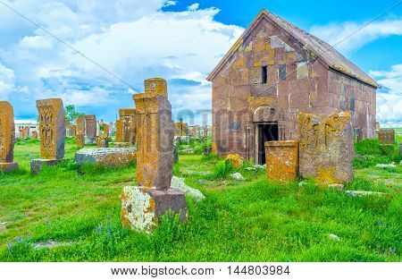 The red travertine chapel among the khachkars at Noratus Cemetery Gegharkunik Province Armenia.