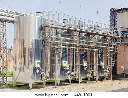 Several stainless steel vessels and pipework and other equipment used for the production of wine in modern winery