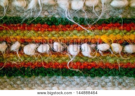 Traditional Ukrainian woven woolen fabric from the Carpathian mountains region. Ethnic pattern in orange, red and green colors. Tradition huzul ornament.