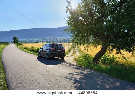 PROVENCE FRANCE - JUL 17 2014: Car on the local tar road along rural field at sunset. Plateau of Sault most popular region for travel in Provence France